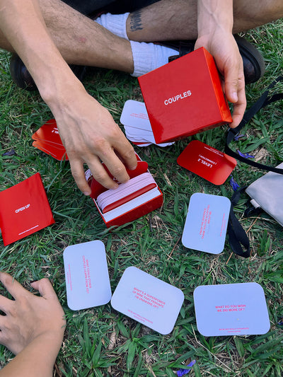 We're Not Really Strangers Couples Edition. Couple playing game while sitting in grass.