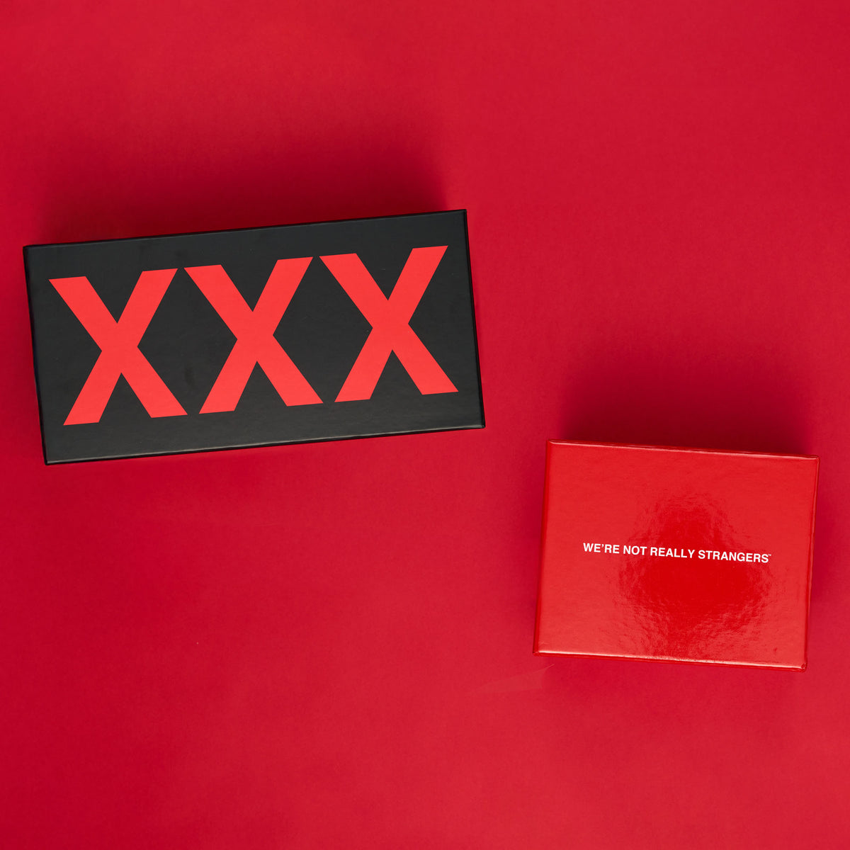 Black card with red XXX text and red card with "We're Not Really Strangers" text on red background.