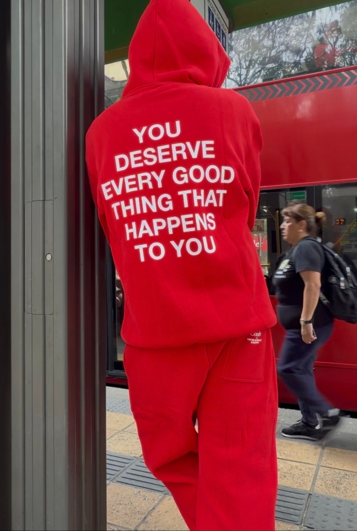 Red sweatsuit with white text on back reading "you deserve every good thing that happens to you," featuring a hoodie and matc
