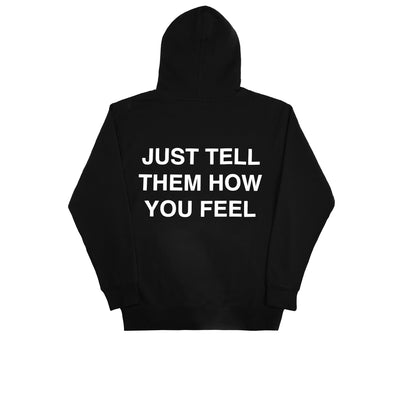 We're Not Really Strangers back side of black hoodie reading "Just tell them how you feel hoodie" in all caps white lettering.