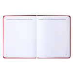 Open guided journal with red cover displaying two pages with reflective prompts and blank writing spaces.