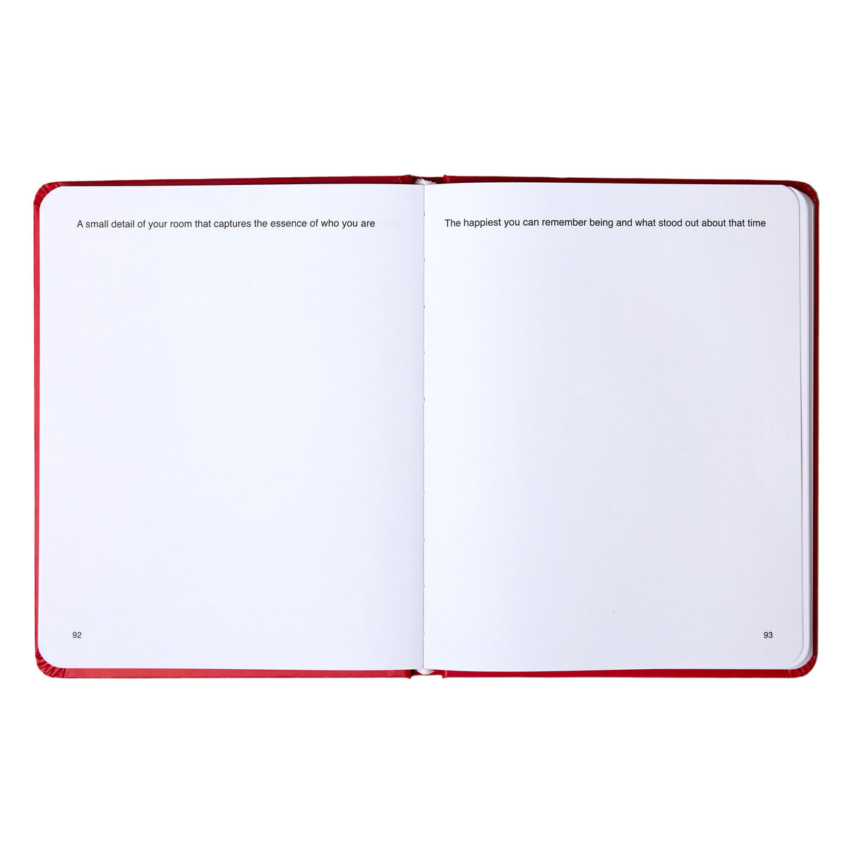 Open guided journal with red cover displaying two pages with reflective prompts and blank writing spaces.