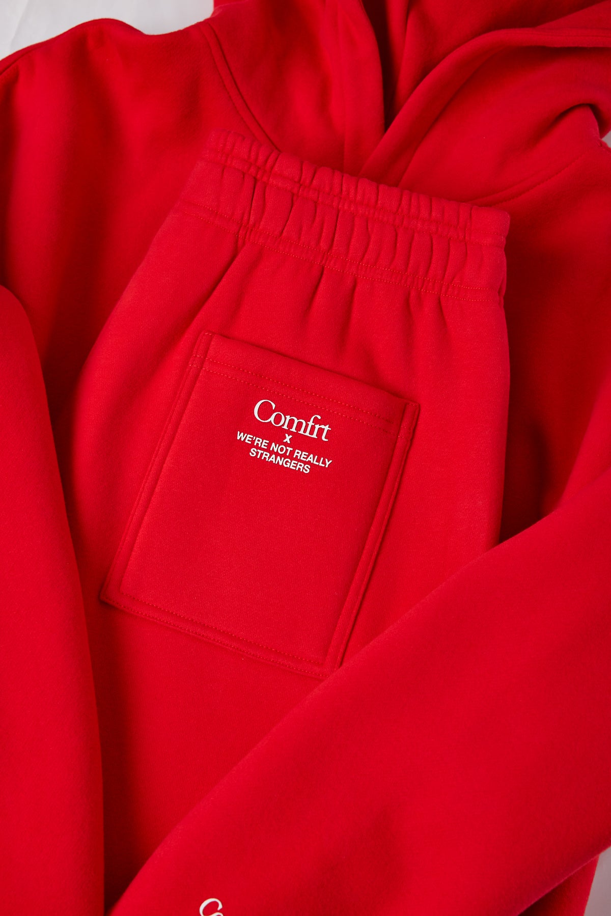 Red sweatshirt and sweatpants set with "Comfrt" logo and text on pocket.