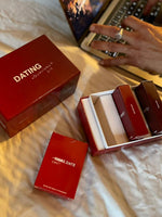 Red "Dating Survival Kit" box with multiple smaller red and burgundy product boxes displayed open, showing contents and label