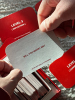 Hand holding white card reading "Will You Marry Me?" with red cards stacked below showing "Level 3 (Reflection)" text.