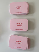 Three pink card decks labeled Level 1 (Past), Level 2 (Present), and Level 3 (Future) with "We're Not Really Strangers Self L