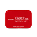 Red rounded rectangle card with white text containing a reminder message and "We're Not Really Strangers Breakup Edition" lab