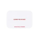 We're Not Really Strangers E-Gift Card. Front facing view of white card option reading "Loving you is easy" in red font.
