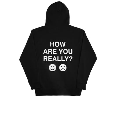 We're Not Really Strangers Mental Health Awareness Month. Back view of Black How Are You Really Hoodie with large white text reading "How Are You Really?" with an emoji smiley face and emoji frown face in white below the text.