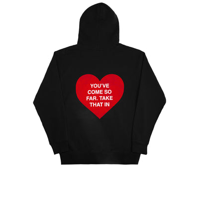 We're Not Really Strangers Black You've Come So Far Hoodie back view of Hoodie with a large red heart in center with white text overlay inside the heart reading "You've Come So Far. Take That In"