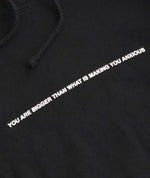 We're Not Really Strangers close up view of black hoodie saying You are bigger than what is making you anxious